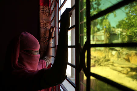 A 12 year old Rohingya girl who worked as domestic help in a house in Bangladesh, looks out the window at an undisclosed location near Cox's Bazar, Bangladesh, November 8, 2017. REUTERS/Mohammad Ponir Hossain