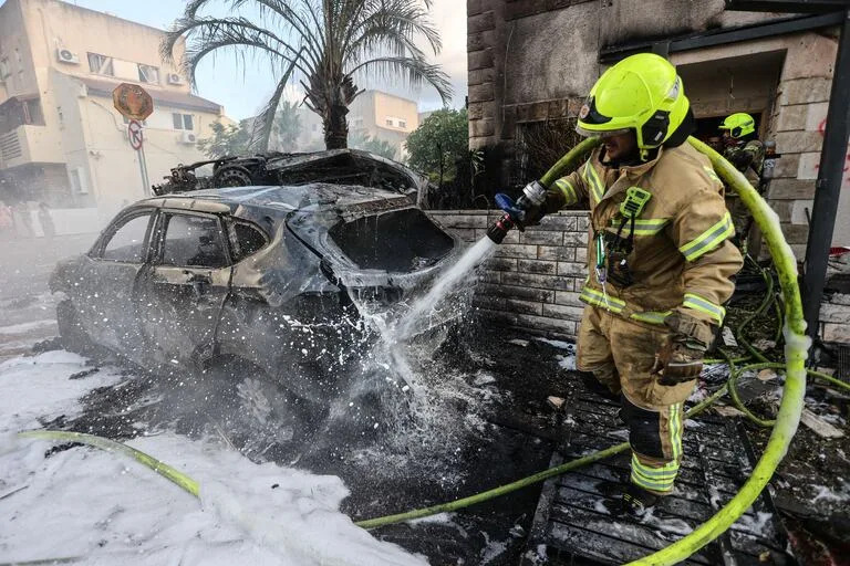 Un bombero israelí extingue fuego en la escena de un ataque con cohetes desde El Líbano, en Kiryat Bialik, en el norte de Israel, el 22 de septiembre de 2024.