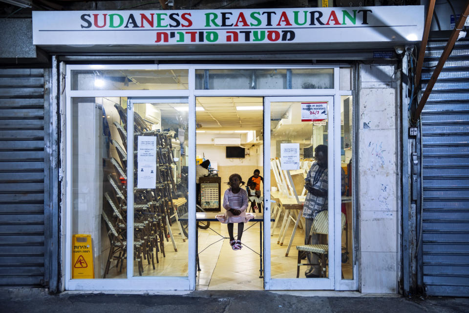 Sudanese migrant family seen in a closed sudanese restaurant in south Tel Aviv, Israel, Tuesday, Oct. 27, 2020. After Israel and Sudan agreed this month to normalize ties, some 6,000 Sudanese migrants in Israel are again fearing for their fate. Israel has long grappled with how to deal with its tens of thousands of African migrants. (AP Photo/Oded Balilty)