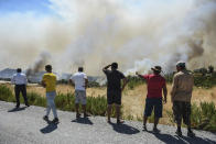 People watch wildfires in Kacarlar village near the Mediterranean coastal town of Manavgat, Antalya, Turkey, Saturday, July 31, 2021. The death toll from wildfires raging in Turkey's Mediterranean towns rose to six Saturday after two forest workers were killed, the country's health minister said. Fires across Turkey since Wednesday burned down forests, encroaching on villages and tourist destinations and forcing people to evacuate. (AP Photo)