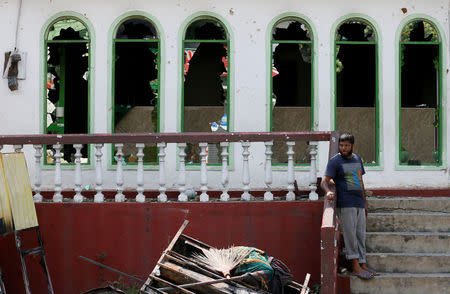 A man stands in front of a damaged mosque after a clash between two communities in Digana, central district of Kandy, Sri Lanka March 8, 2018. REUTERS/Dinuka Liyanawatte/File Photo
