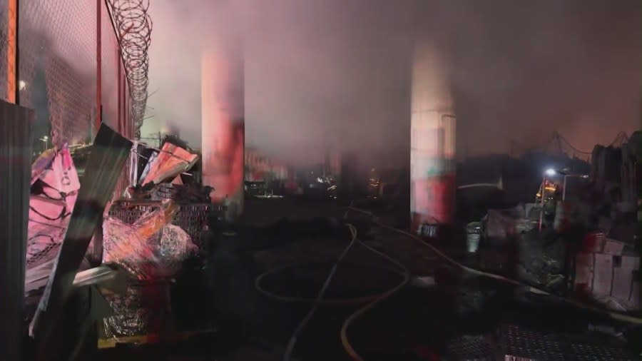 Firefighters battle a fire near an overpass in downtown Los Angeles on Nov. 11, 2023. (KTLA)