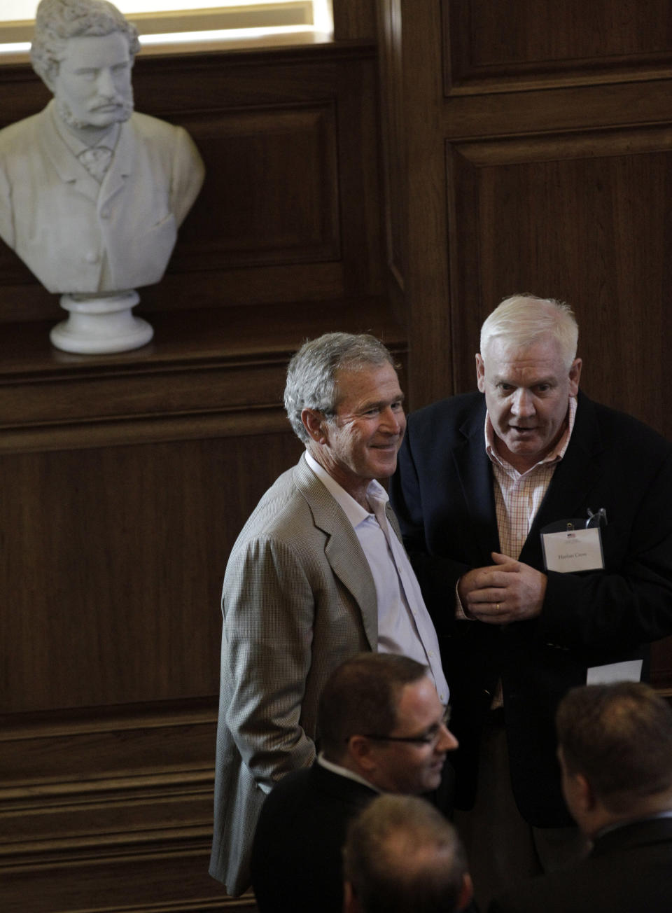 Former President George W. Bush, left, visits with Harlan Crow during a release reception for a book titled "The 4 Percent Solution: Unleashing the Economic Growth America Needs," during a release party Tuesday, July 17, 2012, in Dallas. The George W. Bush Institute is launching its first book, which features experts weighing in on ways for the U.S. to jumpstart the economy toward 4 percent gross domestic product growth. The former president wrote the foreword. (AP Photo/LM Otero)