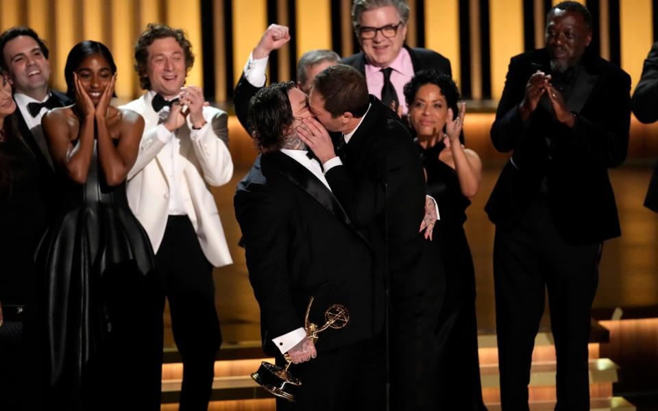 Matty Matheson, center, and Ebon Moss-Bachrach kiss as "The Bear" wins the award for outstanding comedy series during the 75th Primetime Emmy Awards on Monday, Jan. 15, 2024, at the Peacock Theater in Los Angeles