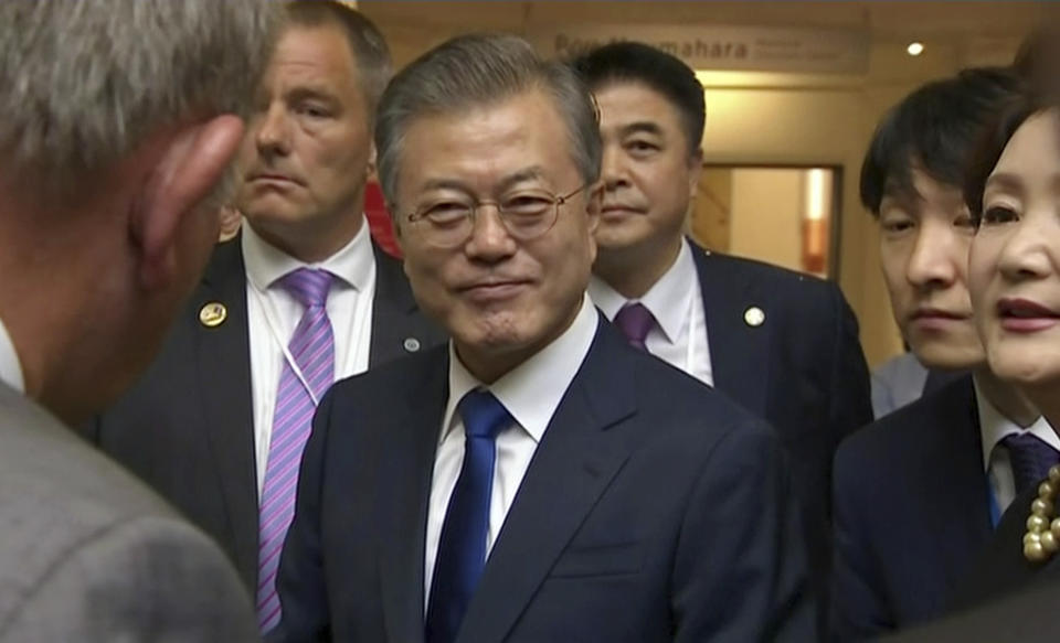 In this image made from a video, South Korean President Moon Jae-in, center, prepares to leave after a wreath laying ceremony at the Auckland War Memorial Museum in Auckland, New Zealand Monday, Dec. 3, 2018. Moon says U.S. President Donald Trump told him he has a "very friendly view" of North Korean leader Kim Jong Un and wants to grant his wishes if he denuclearizes. (TVNZ via AP)