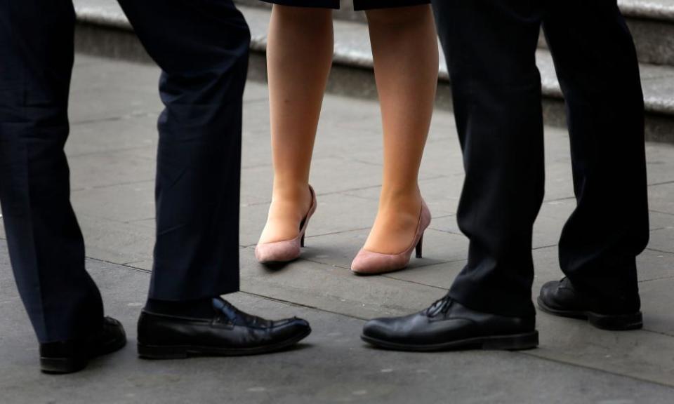 Legs belonging to woman at work, and men in same workplace