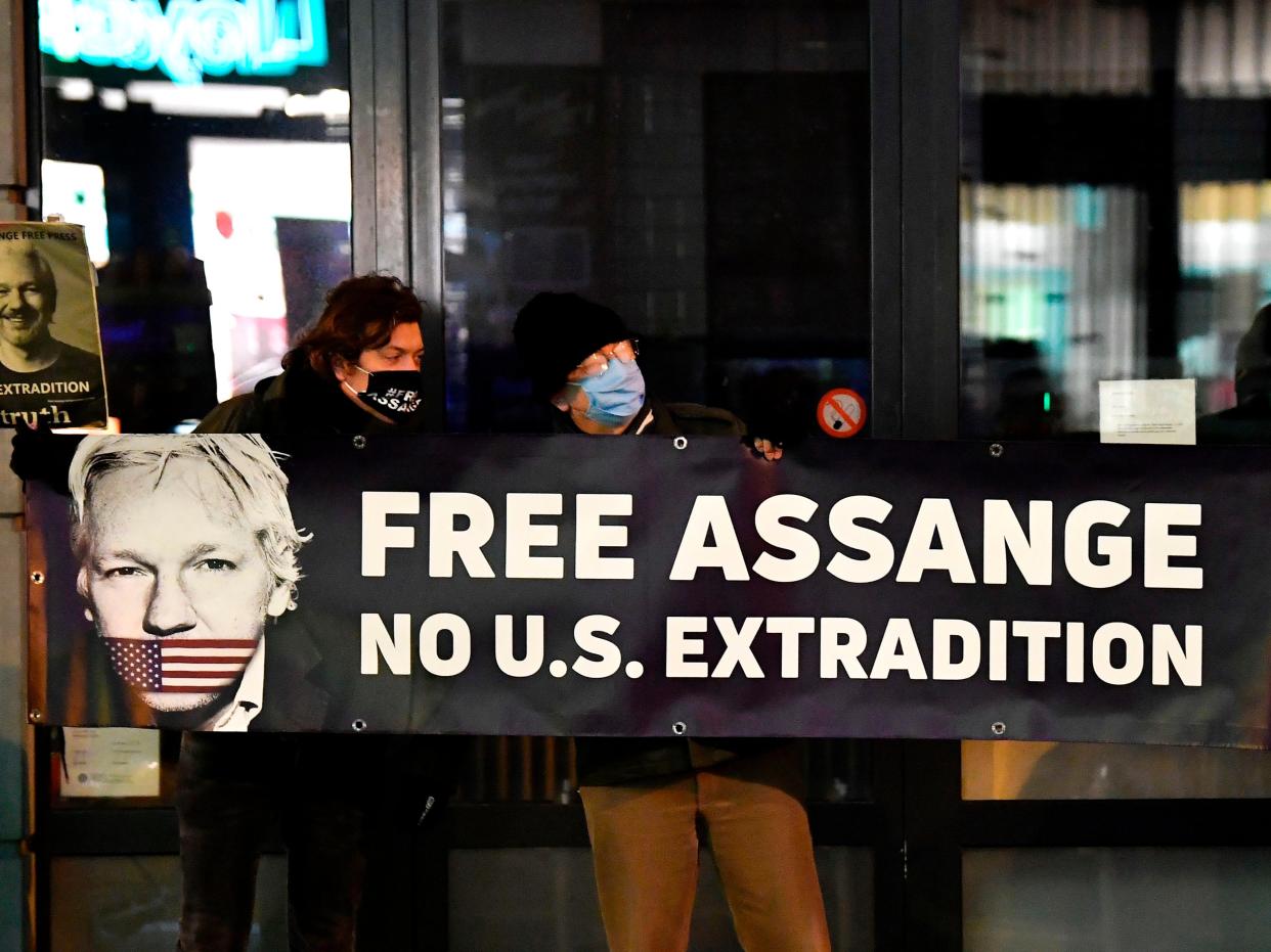 <p>Protesters hold a sign to support WikiLeaks founder Julian Assange in front of the EU British Embassy in Brussels</p> (AFP via Getty Images)
