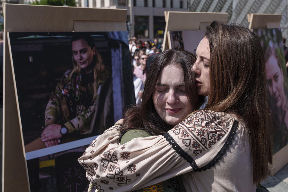 Young women hug each other during a memorial service for the Ukrainian journalist and volunteer combat medic Iryna Tsybukh on Independence square in Kyiv, Ukraine, Sunday, June 2, 2024. Nearly 1,000 people attended a ceremony Sunday honoring the memory of Ukrainian journalist Iryna Tsybukh, who was killed in action while serving as a combat medic a few days before her 26th birthday. Tsybukh was killed while on rotation in Kharkiv area, where Russia started its offensive nearly a month ago. (AP Photo/Evgeniy Maloletka)
