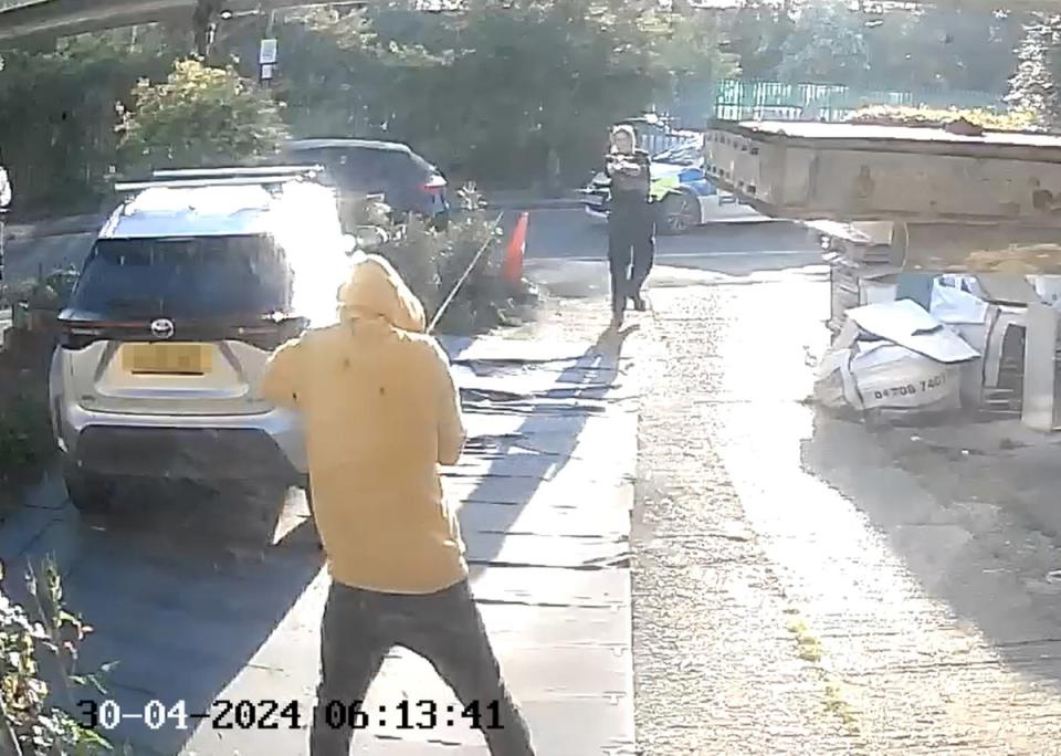 Doorbell camera footage shows police approaching the sword-wielding man in Hainault (PA)