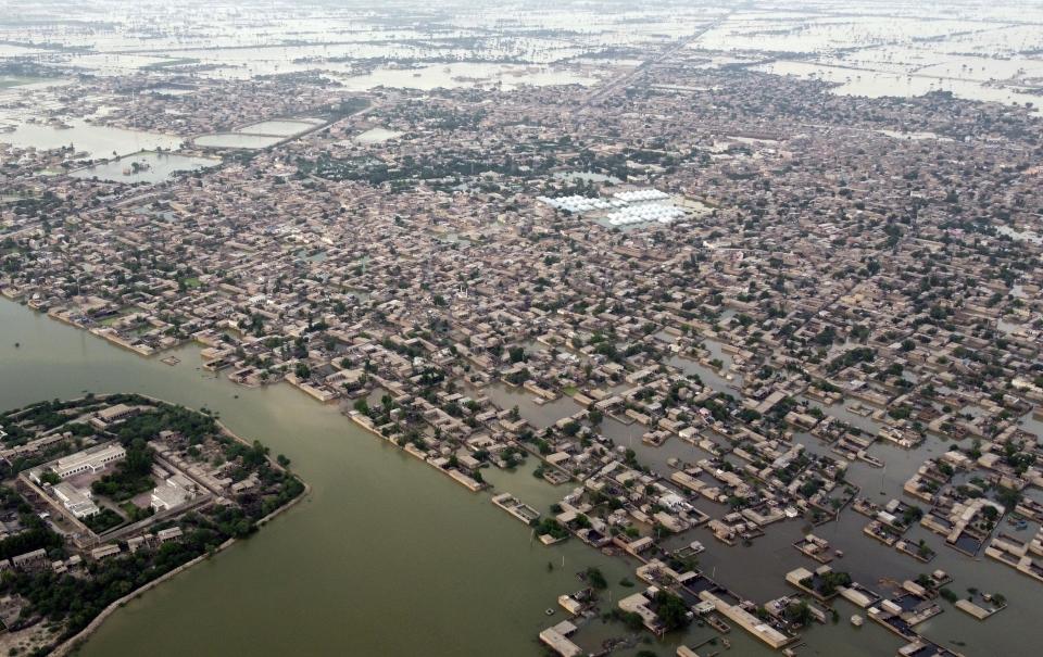 FILE - Homes are surrounded by floodwaters in Jaffarabad, a district of Pakistan's southwestern Baluchistan province, Sept. 1, 2022. The flooding in Pakistan killed at least 1,700 people, destroyed millions of homes, wiped out swathes of farmland, and caused billions of dollars in economic losses. (AP Photo/Zahid Hussain, File)