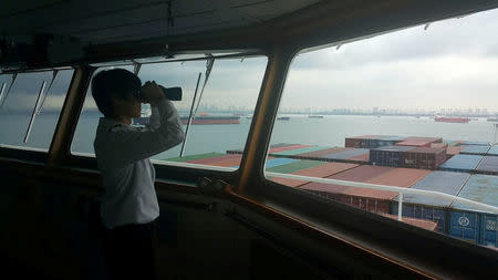 A crew member looks out from Hanjin Rome, stranded off the coast of Singapore, in this undated handout photo received on September 22, 2016. Moon Kwon-do/Handout via Reuters/File Photo .