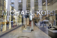 FILE- In this May 31, 2017, file photo the Michael Kors name adorns his store on Madison Avenue, in New York. Michael Kors is buying the Italian fashion house Gianni Versace in a deal worth more than $2 billion in a hard charge into the world of high end fashion. The deal announced Tuesday, Sept. 25, 2018, follows the New York handbag maker’s $1.35 billion acquisition last year of the high-end shoemaker Jimmy Choo. (AP Photo/Richard Drew, File)