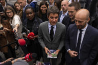 French Prime Minister Gabriel Attal, center campaigns with local candidate for the second round of the legislative election Stanislas Guerini, right, Tuesday, July 2, 2024 in Paris. After France's far-right National Rally surged into the lead in the first round of legislative elections, some European neighbors on Monday cast a wary eye on the latest country to veer to the right on the continent. (AP Photo/Louise Delmotte)