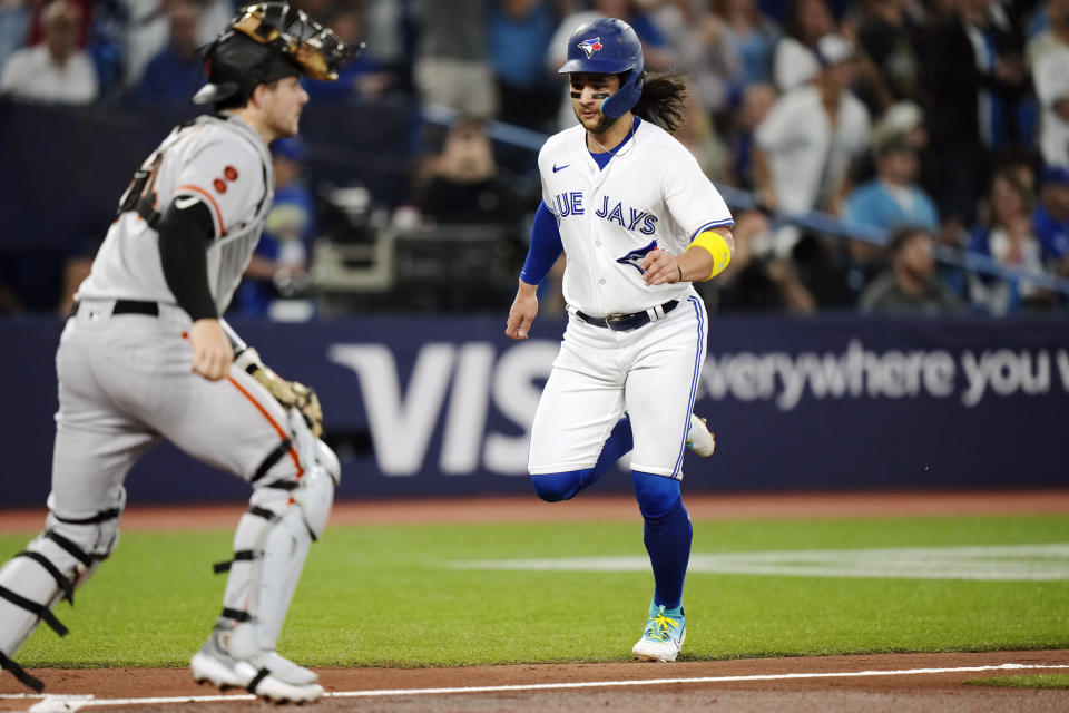 Toronto Blue Jays' Bo Bichette (11) approaches home to score, while San Francisco Giants catcher Patrick Bailey, left, looks to the infield during the first inning of a baseball game Wednesday, June 28, 2023, in Toronto. (Frank Gunn/The Canadian Press via AP)