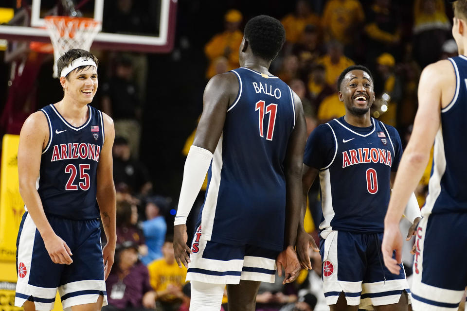 Arizona's Kerr Kris (25) Oumar Ballo (11) and Courtney Ramey (0) celebrate after their win over Arizona State in an NCAA college basketball game, Saturday, Dec. 31, 2022, in Tempe, Ariz. (AP Photo/Darryl Webb)