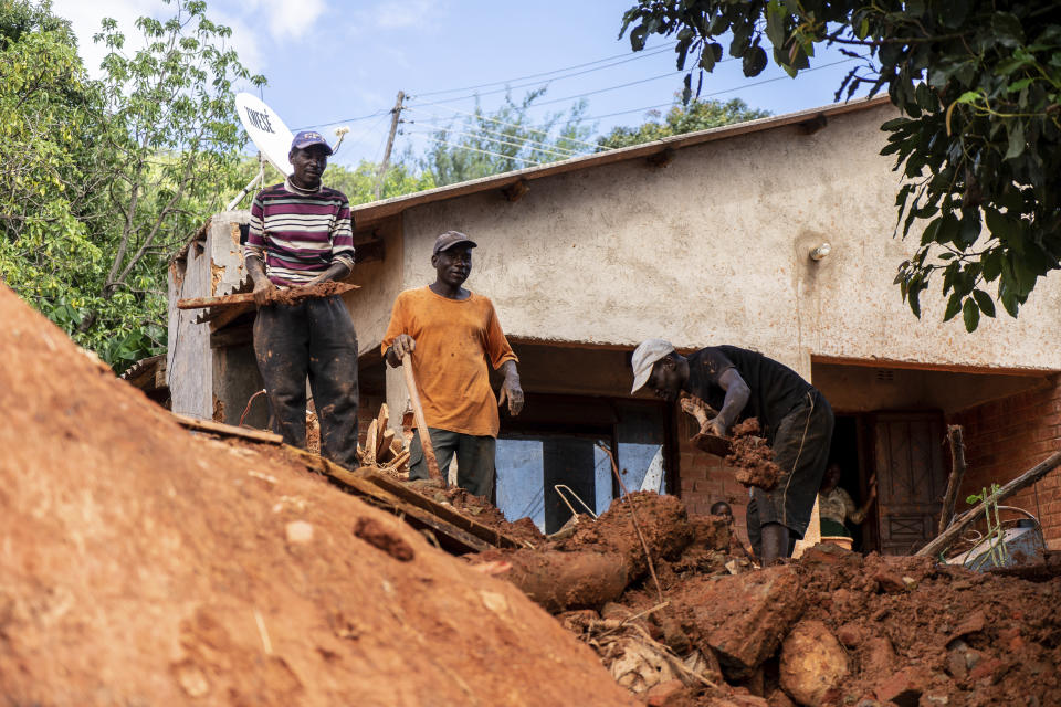 Residents remove mud from their home and yard caused by Cyclone Idai in Chimanimani, Zimbabwe Sunday, March 24 2019. The death toll has risen above 750 in the three southern African countries hit 10 days ago by the storm, as workers restore electricity, water and try to prevent outbreak of cholera, authorities said Sunday. (AP Photo/KB Mpofu)
