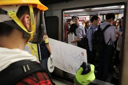 A protester calls people to join further rallies against the government at Kowloon Tong subway station in Hong Kong