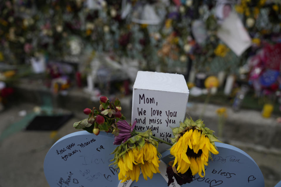 Flowers and messages of love adorn a wooden heart marked with the name Francis Fernandez, alongside a memorial wall for the victims of the Champlain Towers South building collapse, on Monday, July 12, 2021, in Surfside, Fla.(AP Photo/Rebecca Blackwell)
