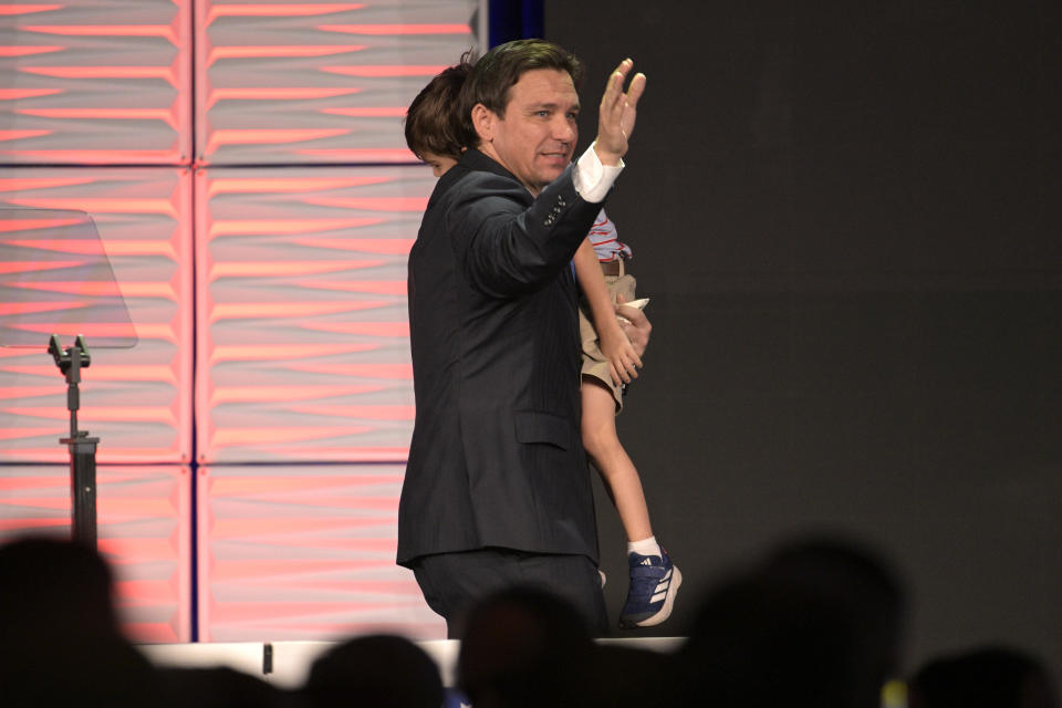 Republican presidential candidate Florida Gov. Ron DeSantis waves to attendees, while carrying his son Mason, after speaking at the Republican Party of Florida Freedom Summit, Saturday, Nov. 4, 2023, in Kissimmee, Fla. (AP Photo/Phelan M. Ebenhack)