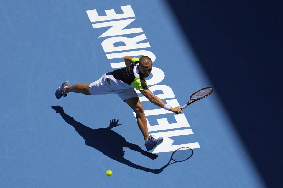 Daniel Evans of Britain plays a backhand return to Andrey Rublev of Russia during their third round match at the Australian Open tennis championship in Melbourne, Australia, Saturday, Jan. 21, 2023. (AP Photo/Ng Han Guan)