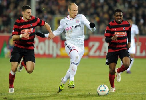 Bayern Munich's Arjen Robben (C) and Freiburg's Karim Guede (R) and Daniel Caligiuri (L) during their German league match on February 18. Bayern came off second best to a spirited Freiburg team who are threatened with relegation