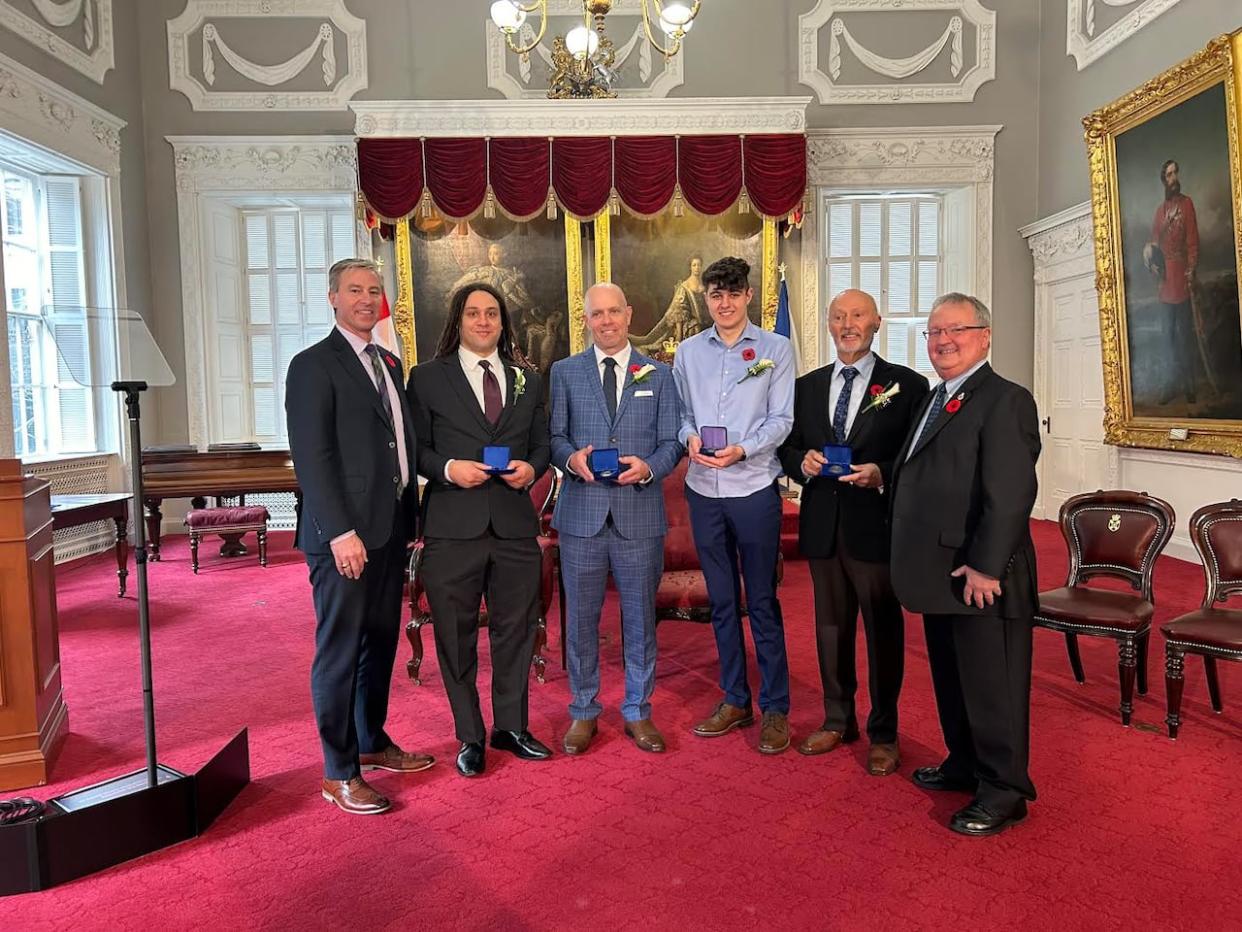 The medal of bravery is given to four Nova Scotians on Wednesday who risked their lives protecting others. From left, Premier Tim Houston, recipients Talbot Boyer, Scott Buchanan, Adam Lefort, Robert McGregor and medal committee chair Tom Steele. (Tehosterihens Deer - image credit)