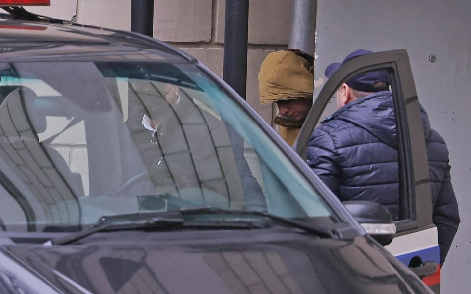 Evan Gershkovich is escorted to a car outside a court building in Moscow on Thursday - Evgenia Novozhenina/Reuters