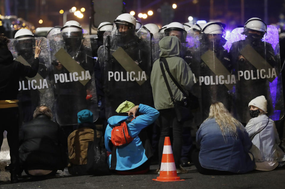 A police cordon guards the house of Poland's ruling conservative party leader Jaroslaw Kaczynski against a crowd protesting a decision by the Constitutional Court, in Warsaw, Poland, on Friday, Oct. 23, 2020. Poland’s top court ruled Thursday that a law allowing abortion of fetuses with congenital defects is unconstitutional, shutting a major loophole in the predominantly Catholic country's abortion laws that are among the strictest in Europe. Defying the pandemic-related ban on gatherings, the protesters chanted for the government to resign. (AP Photo/Czarek Sokolowski)