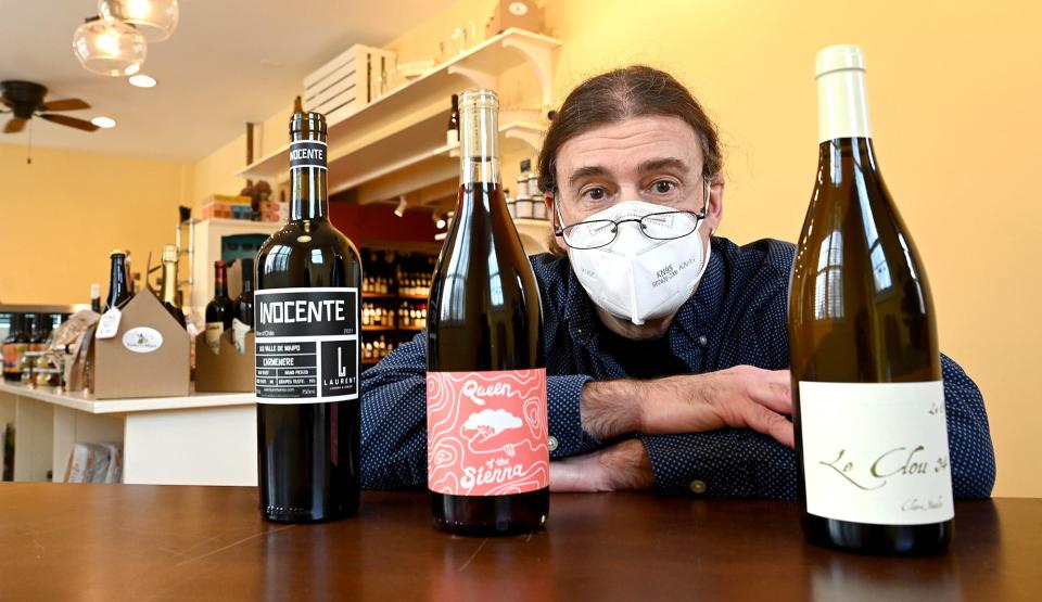 Richard Schnitzlein, owner of Fiske & Main Specialty Wine and Cheese in Upton, with bottles of a Vina Laurent 2021 Carmenere "Inocente," left, a French grape wine; Forlorn Hope 2019 "Queen of the Sierra," a red wine that is a blend of Zinfandel and other grapes; and a Claire Naudin 2019 "Le Clou 34," a wine from Burgundy, France, Feb. 16, 2022.