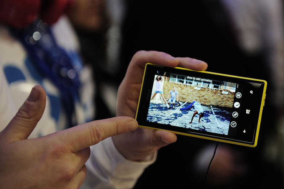 A man holds the new Nokia Lumia 720 at the Mobile World Congress. Nokia unveiled a cheaper model in its Lumia smart phone range, powered by Microsoft's Windows phone software, as it tries to regain dominance in emerging markets like China. Nokia CEO Stephen Elop also revealed the Lumia 720, a higher-priced smart phone for countries like China that lack advanced wireless data networks. He said China Mobile, the world's largest cellphone company, will sell both models.