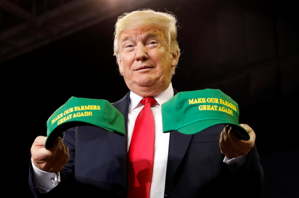 U.S. President Donald Trump holds “Make Our Farmers Great Again!” hats during a rally in Indiana, but the shutdown is putting his farmer bailout on hold. (Photo: REUTERS/Kevin Lamarque)