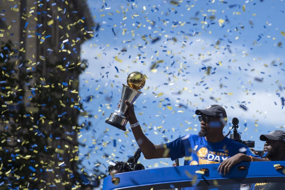 <p>Golden State Warriors forward Kevin Durant (35) hoists the MVP trophy during the Warriors 2017 championship victory parade in downtown Oakland. Mandatory Credit: Kyle Terada-USA TODAY Sports </p>