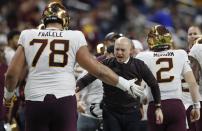 FILE - Minnesota head coach P.J. Fleck greets offensive lineman Daniel Faalele (78) after a play during the Quick Lane Bowl NCAA college football game against Georgia Tech in Detroit, in this Wednesday, Dec. 26, 2018, file photo. This mammoth lineman – he’s 6-foot-9 and 380 pounds – was Minnesota’s starting right tackle in 2018 and 2018. He should step right back into that role this year after sitting out the 2020 season. (AP Photo/Carlos Osorio, File)