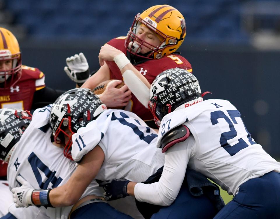 Warren JFK defenders Thomas Valent, Caleb Hadley and Ambrose Hoso try to stop New Bremen's Davie Homan in the first quarter of the the OHSAA Division VII state final at Tom Benson Hall of Fame Stadium. Saturday, Dec. 3, 2022.