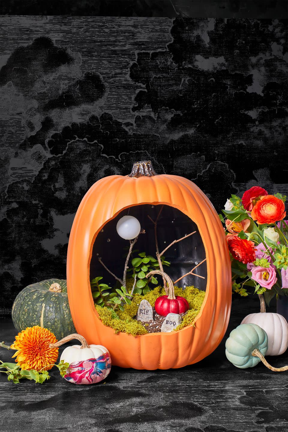 <p>Add drama to your carved pumpkin by filling it with everything from reindeer moss and twigs to mini headstones. Complete the over-the-top design with a full moon (a Ping-Pong ball that you can easily hang from a thin string). </p><p><a class="link " href="https://www.amazon.com/SuperMoss-23080-Reindeer-Moss-Preserved/dp/B01C5RTP7Y/ref=sr_1_4?tag=syn-yahoo-20&ascsubtag=%5Bartid%7C10055.g.238%5Bsrc%7Cyahoo-us" rel="nofollow noopener" target="_blank" data-ylk="slk:SHOP REINDEER MOSS;elm:context_link;itc:0;sec:content-canvas">SHOP REINDEER MOSS</a></p>