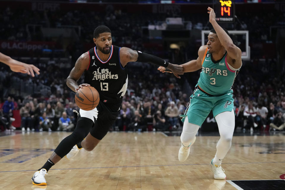 San Antonio Spurs forward Keldon Johnson (3) defends against Los Angeles Clippers guard Paul George (13) during the second half of an NBA basketball game in Los Angeles, Thursday, Jan. 26, 2023. (AP Photo/Ashley Landis)