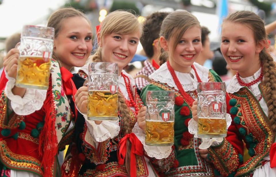 Polish girls dressed in traditional costume enjoy beer after participating in the opening parade.