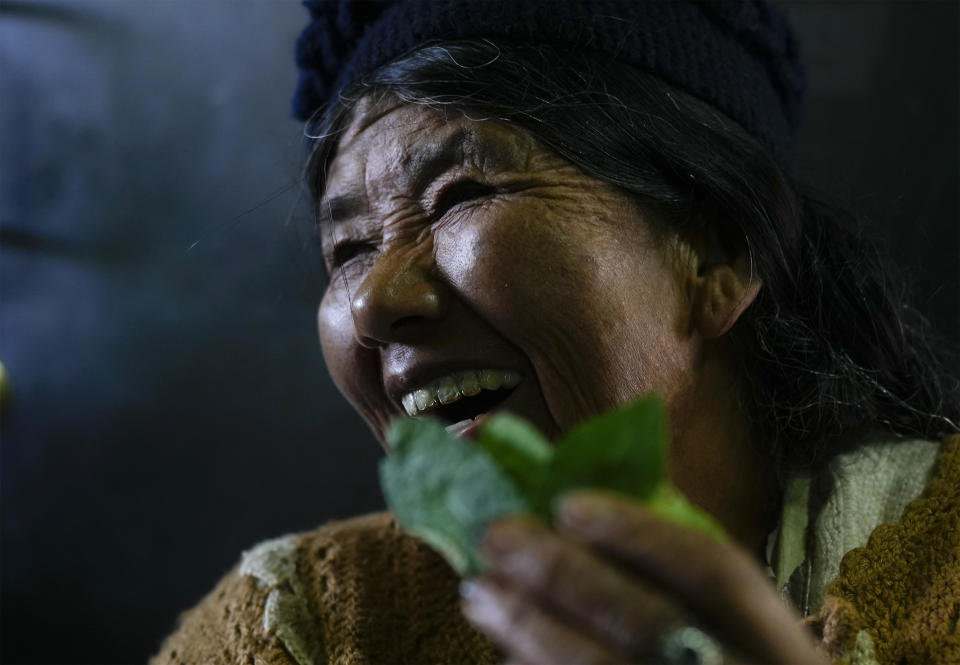 Una vendedora ríe mientras trabaja en un mercado legal de hojas de coca el 18 de abril de 2024, en La Paz, Bolivia. (AP Foto/Juan Karita)