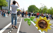 A man with a giant balloon of a sunflower tethered to himself waits for the start of a march by demonstrators down Pennsylvania Avenue during a People's Climate March, to protest U.S. President Donald Trump's stance on the environment, in Washington, U.S., April 29, 2017. REUTERS/Mike Theiler