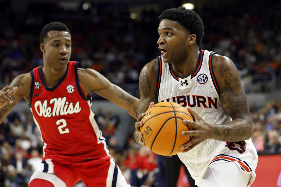 Auburn guard K.D. Johnson drives the baseline around Mississippi guard TJ Caldwell (2) during the second half of an NCAA college basketball game Saturday, Jan. 20, 2024, in Auburn, Ala. (AP Photo/Butch Dill)