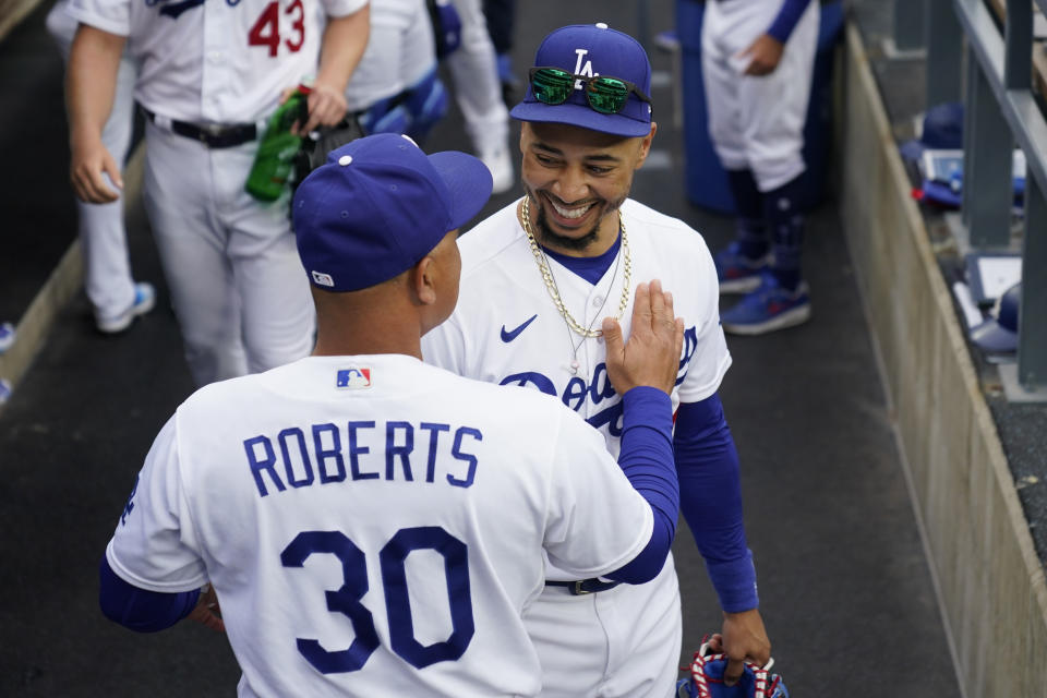 Los Angeles Dodgers manager Dave Roberts (30) greets right fielder Mookie Betts (50) in the dugout before a baseball game against the Washington Nationals in Los Angeles, Wednesday, May 31, 2023. (AP Photo/Ashley Landis)