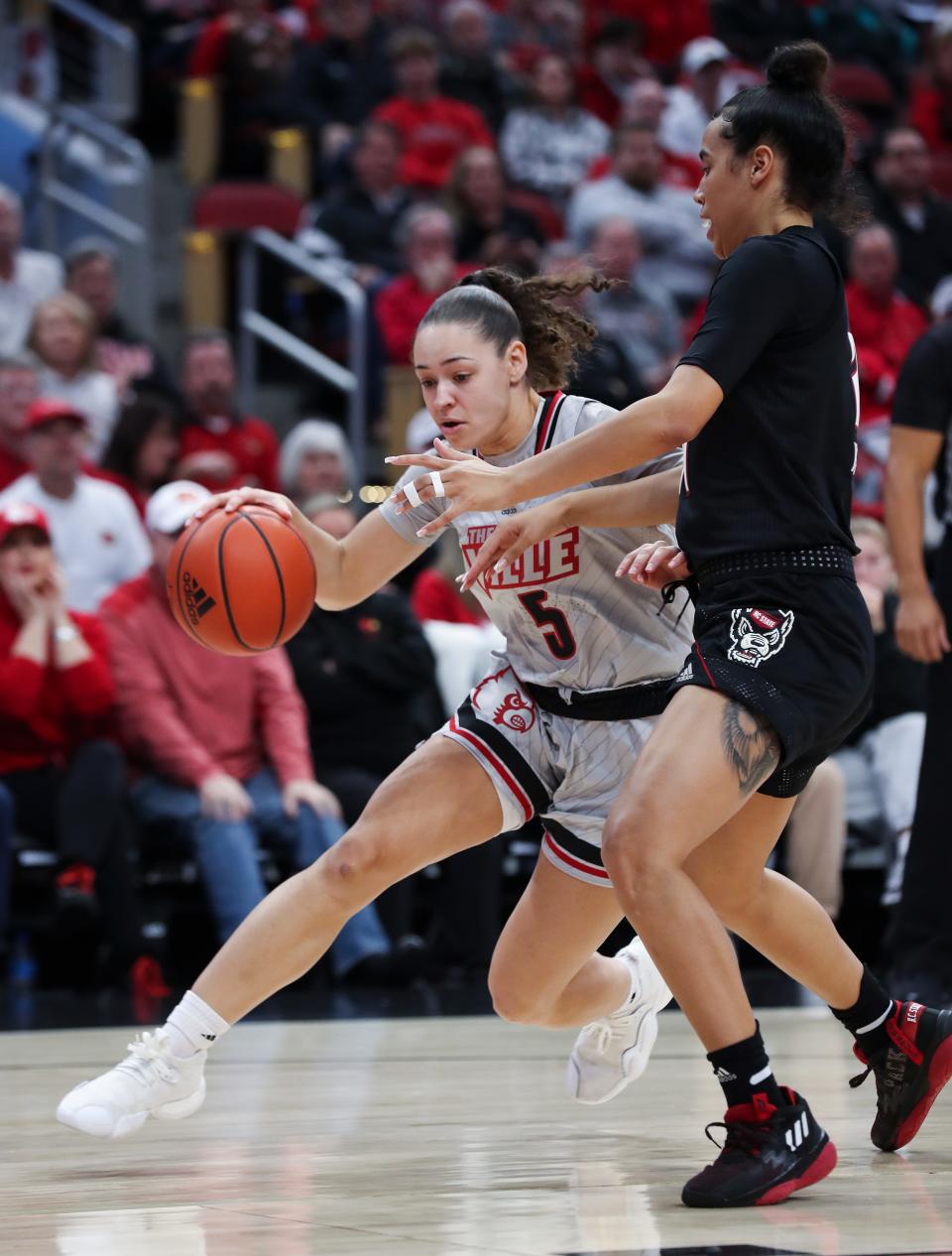 U of L's Mykasa Robinson (5) drove against NC State's Madison Hayes (21) during their game at the Yum Center in Louisville, Ky. on Jan. 22, 2023.