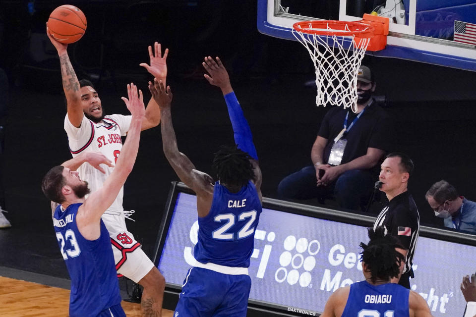 St. John's guard Julian Champagnie (2) goes to the basket against Seton Hall forward Sandro Mamukelashvili (23) and guard Myles Cale (22) during the first half of an NCAA college basketball game in the quarterfinals of the Big East conference tournament, Thursday, March 11, 2021, in New York. (AP Photo/Mary Altaffer)