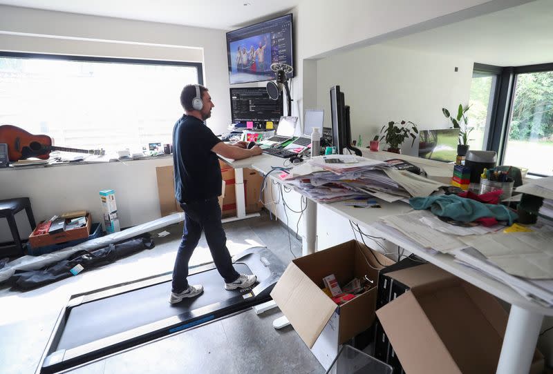 Belgian Yves Hanoulle, IT professional, walks on a treadmill as he works in his home in Ghent