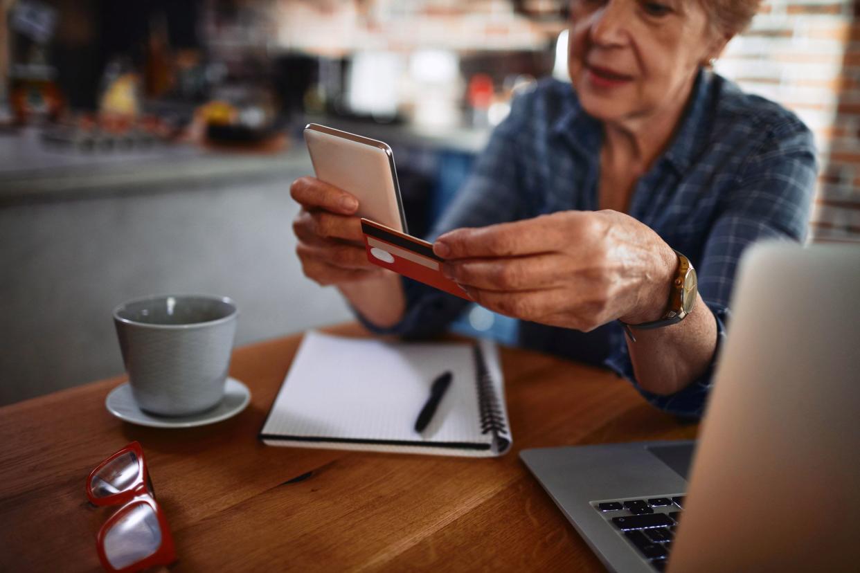 senior holding credit card and phone