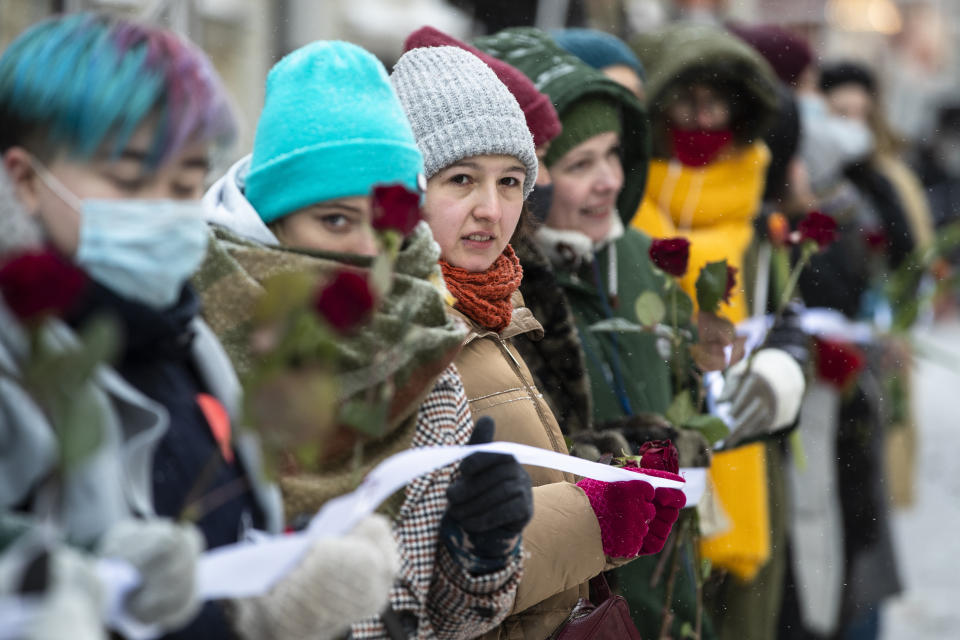 Women hold a white ribbon as they stand in a line of women during a rally in support of jailed opposition leader Alexei Navalny and his wife Yulia Navalnaya at Arbat street in Moscow, Russia, Sunday, Feb. 14, 2021. (AP Photo/Pavel Golovkin)