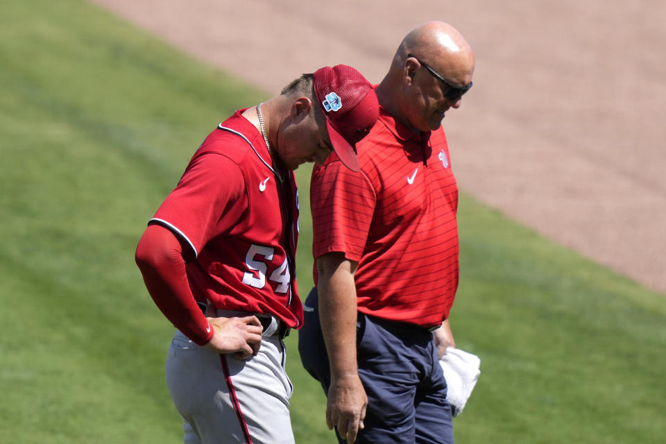 Washington Nationals starting pitcher Cade Cavalli, left, leaves the game during the third inning of a spring training baseball game against the New York Mets, Tuesday, March 14, 2023, in Port St. Lucie, Fla. (AP Photo/Lynne Sladky)