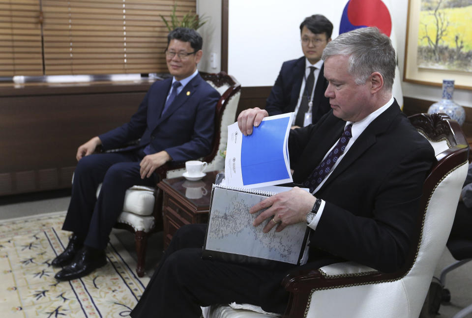 U.S. Special Representative for North Korea Stephen Biegun, right, pulls out documents during a meeting with South Korean Unification Minister Kim Yeon Chul, left, at the government complex in Seoul, South Korea, Friday, May 10, 2019. The U.S. and South Korean militaries evaluated the two projectiles North Korea flew Thursday as short-range missiles, a South Korean military official said Friday, a day after the North's second launch in five days raised jitters about an unravelling detente between the Koreas and the future of nuclear negotiations between Washington and Pyongyang. (AP Photo/Ahn Young-joon)