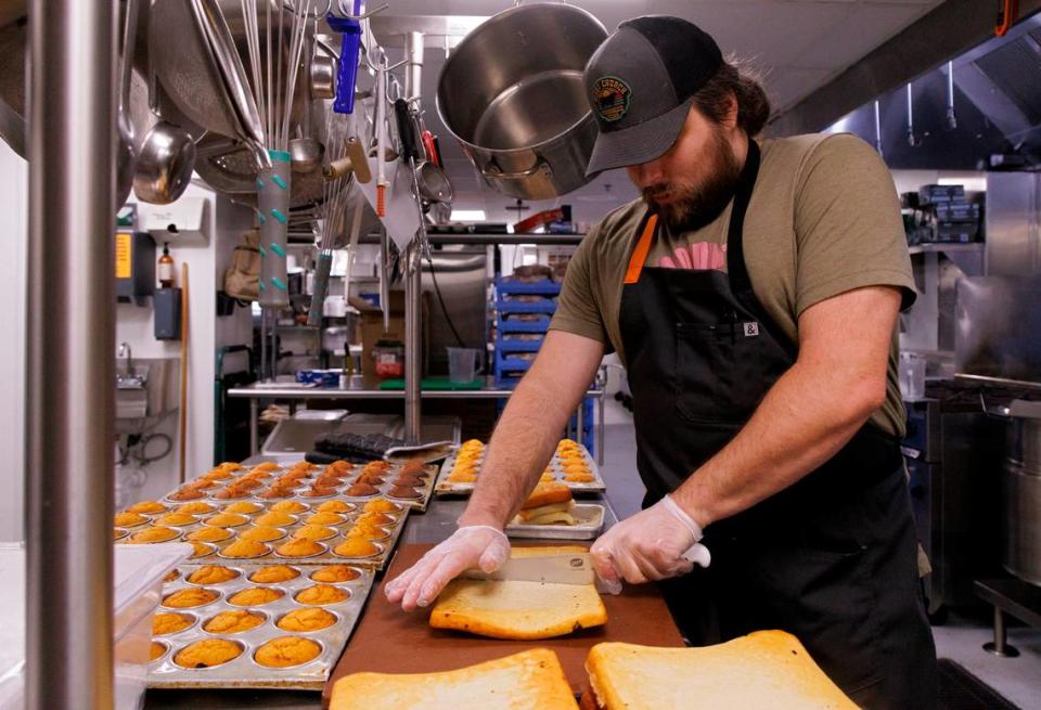 Adam Bauer, kitchen manager at Sam Jones BBQ, slices cornbread at the restaurant on Wednesday, June 5, 2024, in Raleigh, N.C.