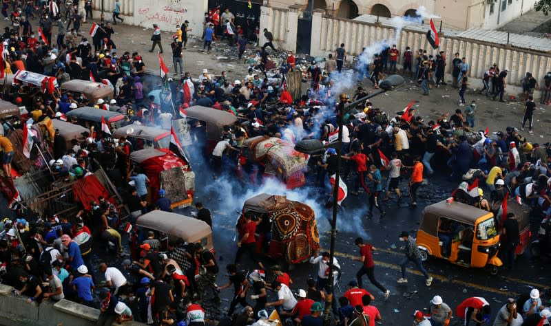 Demonstrators disperse after Iraqi security forces fired tear gas during a protest over corruption, lack of jobs, and poor services, in Baghdad